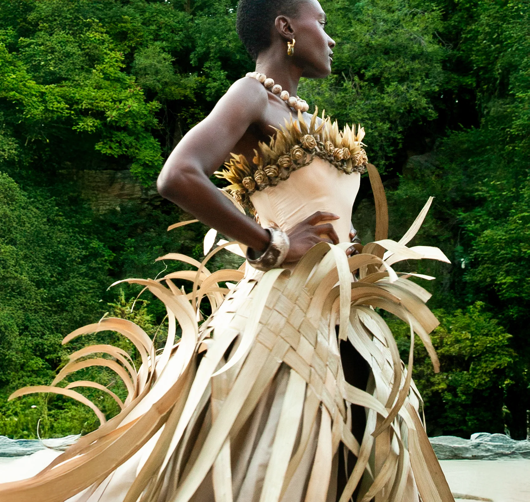 Model in a woven palm-strip gown with a feathered rosette bodice