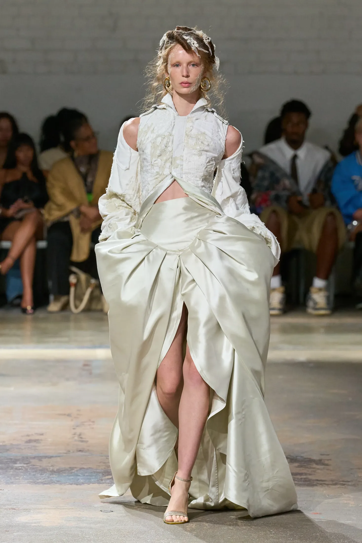 Runway look: distressed white jacket over a draped ivory satin skirt